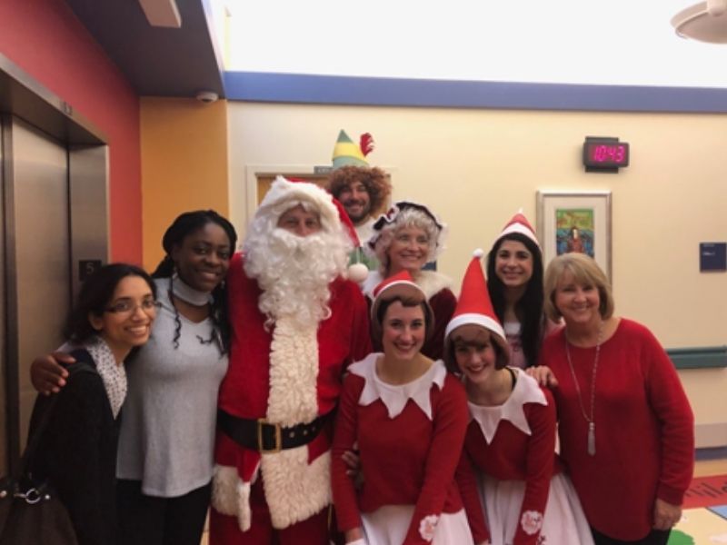 Students dressed as elves pose with Santa.